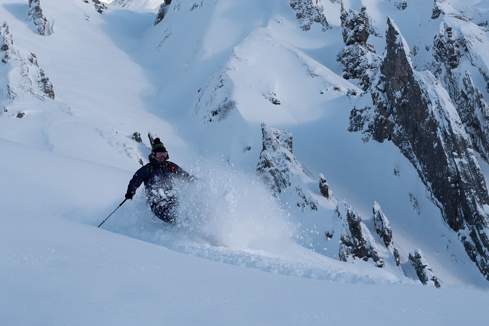 A freerider in deep powder below the rocky flanks of the Arlberg.