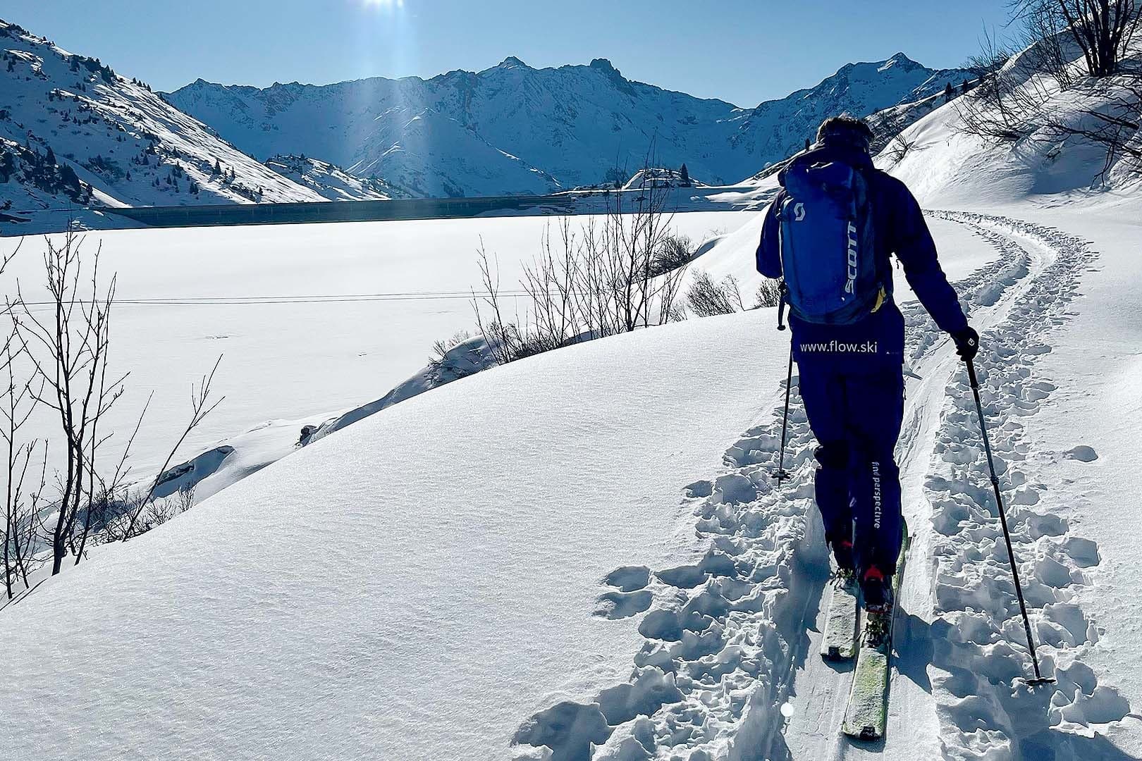 A ski tourer climbing a quiet slope in the morning light.